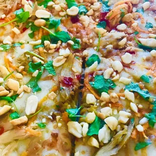 Thai Chicken: peanut sauce, mozzarella, farm chicken, roasted onions, sweet chili sauce, fresh pea shoots, cilantro, and peanuts