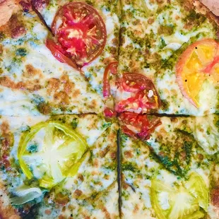 Pesto: Walnut pesto, garlic, parmesan, mozzarella, roasted onions, and seasonal tomatoes