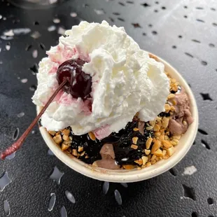 a sundae topped with whipped cream and cherries