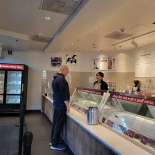 a man standing at a counter in a restaurant