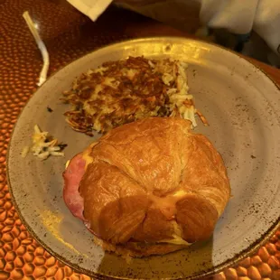 Croissant sandwich with ham and hash browns