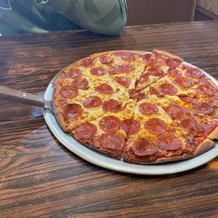 a pepperoni pizza on a pizza pan