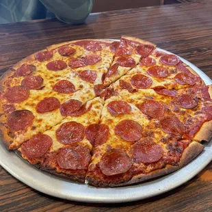 a pepperoni pizza on a pizza pan