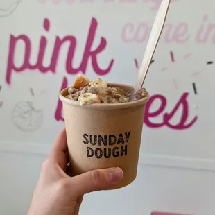 a hand holding a cup of ice cream