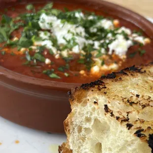 a bowl of soup and a piece of bread