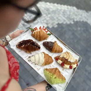 a woman holding a tray of pastries