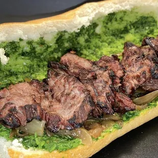 a steak sandwich with broccoli and onions