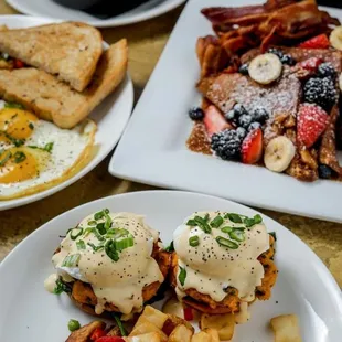 a breakfast of eggs, hash browns, toast, and fruit