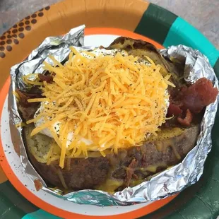 a plate with a baked potato covered in cheese