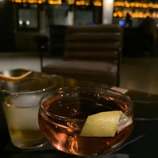 a glass of wine with a lemon garnish