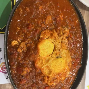 a bowl of chili with an egg in it