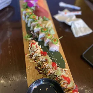 a long sushi roll on a wooden platter