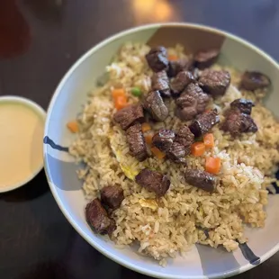 Steak fried rice with a side of yum yum sauce