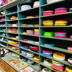 Sunflower has a wall of shelves loaded with discs and bags for disc golf and Ultimate players.