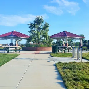 Entry walkway to Sungold Park. There are two covered searing areas with two tables under each cover. And 6 uncovered tables. 2 BBQ pits.