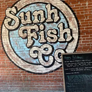 a brick wall with a sign and chalk board