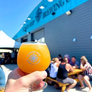 a person holding a glass of beer