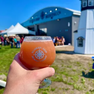 a hand holding a glass of beer