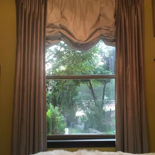 Balloon shade and pinch pleated drapes on a iron rod.