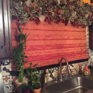 Flat Roman shade with a silk flower valance adorns this kitchen