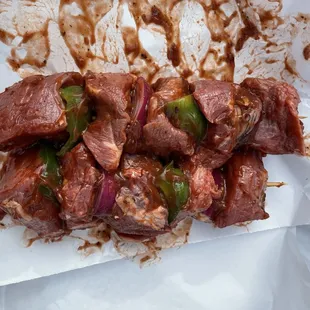 a meat skewer with onions and peppers