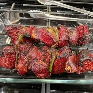 a glass dish of meat wrapped in bacon