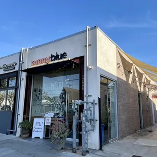 the outside of a restaurant with a sign on the sidewalk