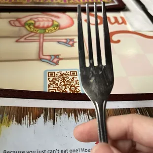 Dirty fork among lots of other dirty silverware