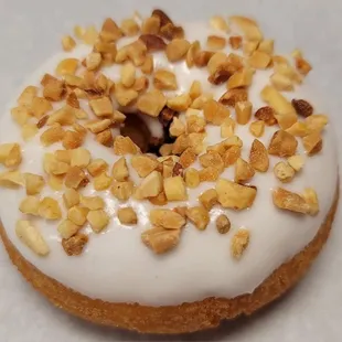 a frosted donut with nuts on top