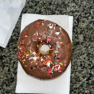 a chocolate frosted donut with sprinkles