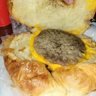 The inside of a sausage, cheese, eggs croissant.