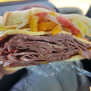 Roast beef, baby swiss, lettuce, tomato, onion, and peppers and mustard on sour dough bread.