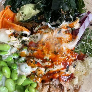 Spicy Tuna Poke Bowl with brown rice, arugula sprouts, carrots, chili tosazu, crispy shallot, cucumber, edamame, ginger, seaweed