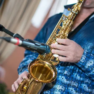 a man playing a saxophone in front of a microphone