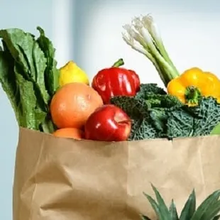 a grocery bag full of fruits and vegetables