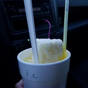 a hand holding a cup of ice cream