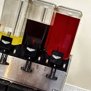 three juice dispensers on a counter