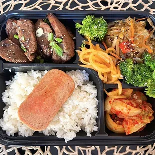 Sunny's Bento w/ galbi steak, spam, kimchi, japchae, sesame broccoli, radish kimchi | $19.85