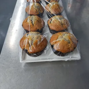 a tray of muffins wrapped in plastic
