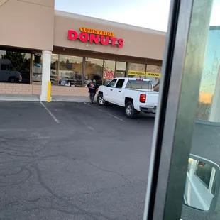 a white truck parked in front of a donut shop
