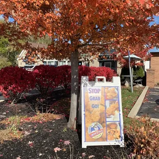 a sign in front of a tree