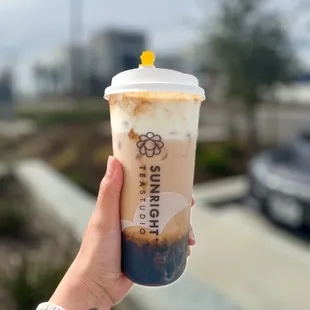 a hand holding a cup of iced coffee