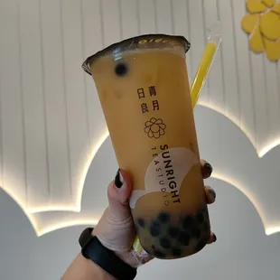 a hand holding a cup of bubble tea