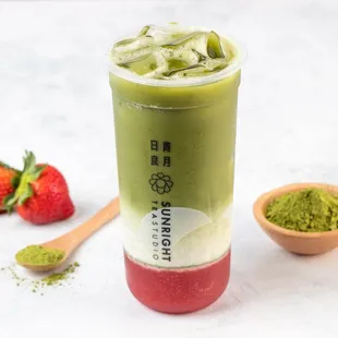 a cup of matcha tea and strawberries