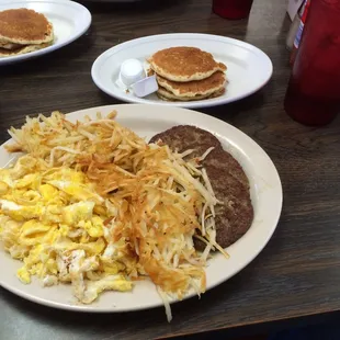 a breakfast of eggs, hash browns and pancakes