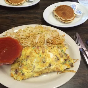 an omelet, hash browns, and pancakes