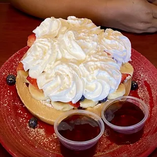 Waffles with strawberry, banana and whip cream.