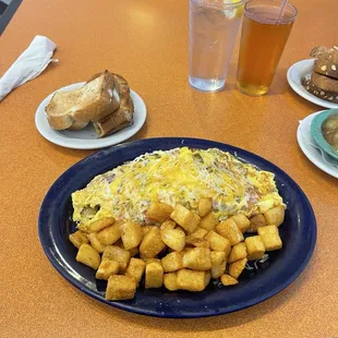 Meat lovers Omelette, Hash Browns, and White Toast. Apple juice and Water