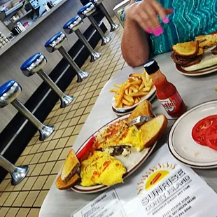 a woman sitting at a table with plates of food