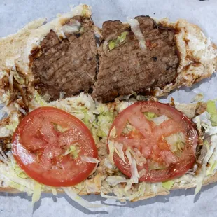 a hamburger sandwich with tomatoes and lettuce